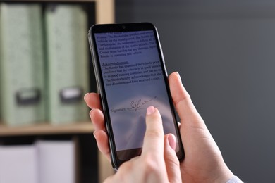 Photo of Electronic signature. Woman using smartphone indoors, closeup