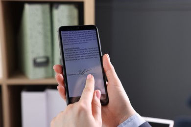 Photo of Electronic signature. Woman using smartphone indoors, closeup