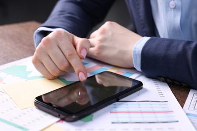 Photo of Electronic signature. Woman using smartphone at table, closeup