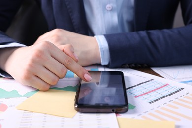 Photo of Electronic signature. Woman using smartphone at table, closeup