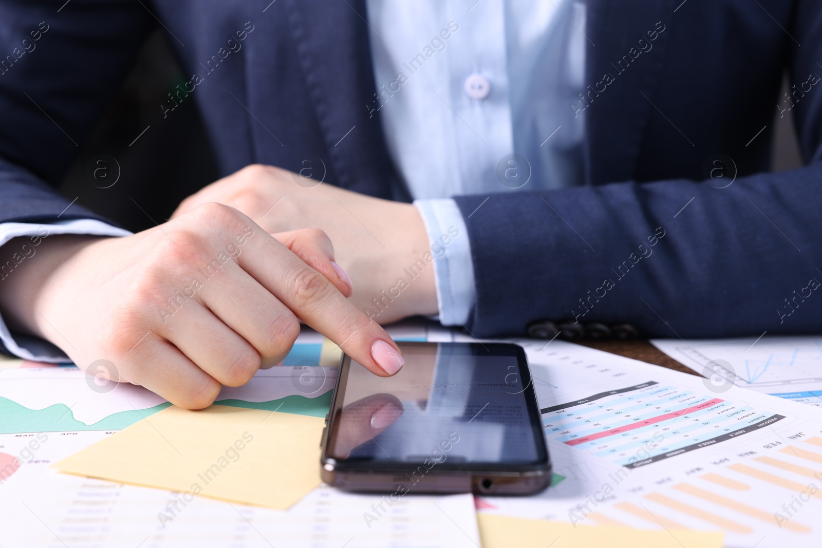 Photo of Electronic signature. Woman using smartphone at table, closeup