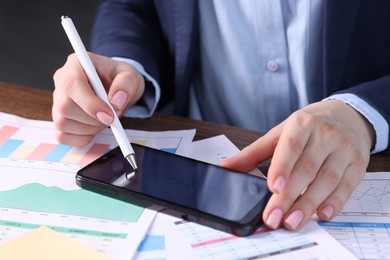 Photo of Electronic signature. Woman using stylus and smartphone at wooden table, closeup