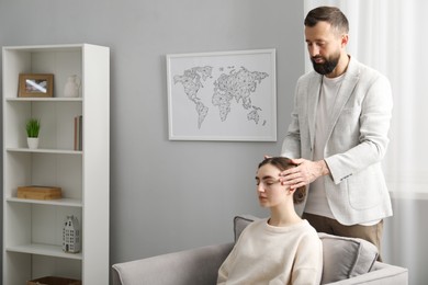 Photo of Psychologist working with patient during hypnosis session indoors