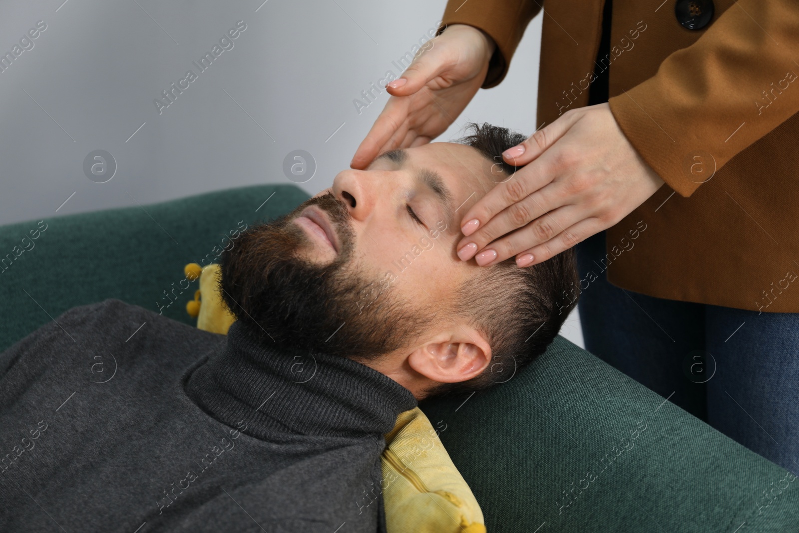 Photo of Psychologist working with patient during hypnosis session indoors, closeup