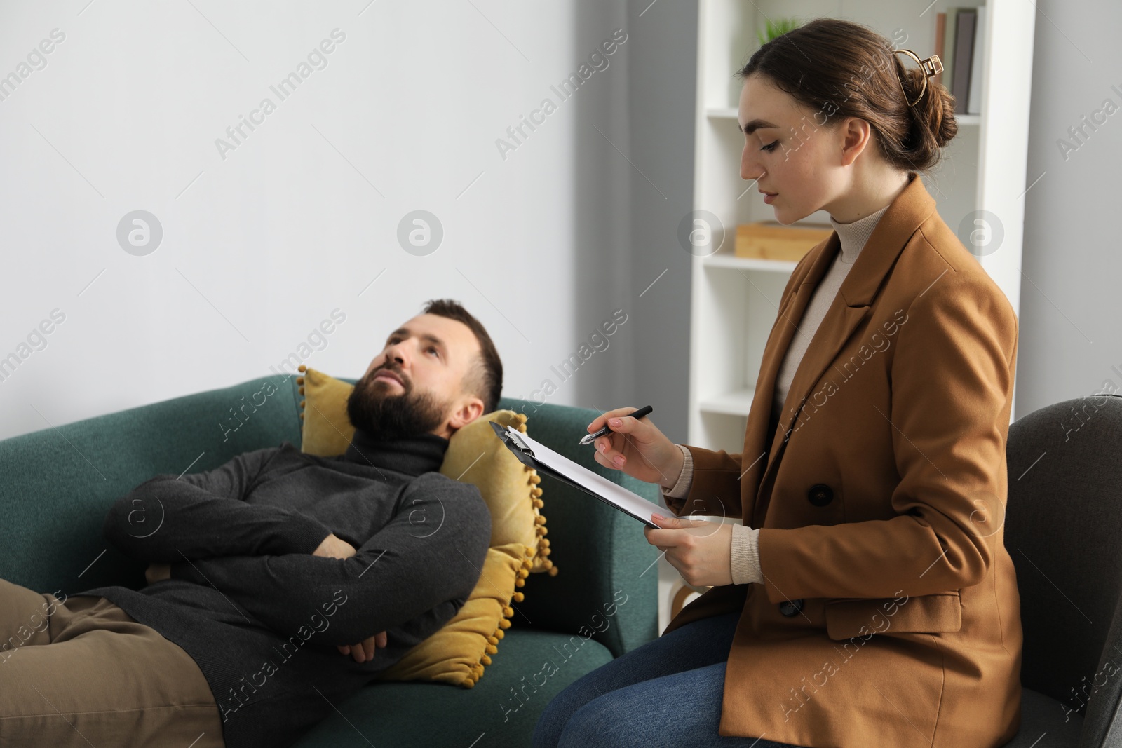 Photo of Psychologist working with patient during hypnosis session indoors