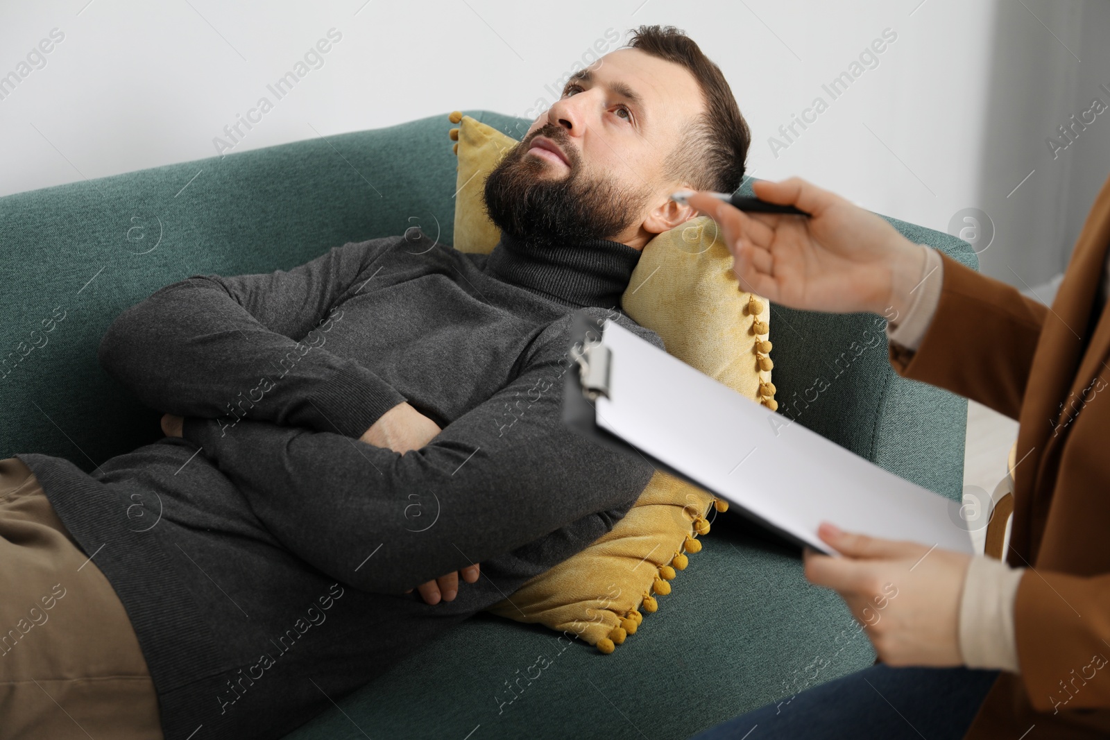 Photo of Psychologist working with patient during hypnosis session indoors, closeup