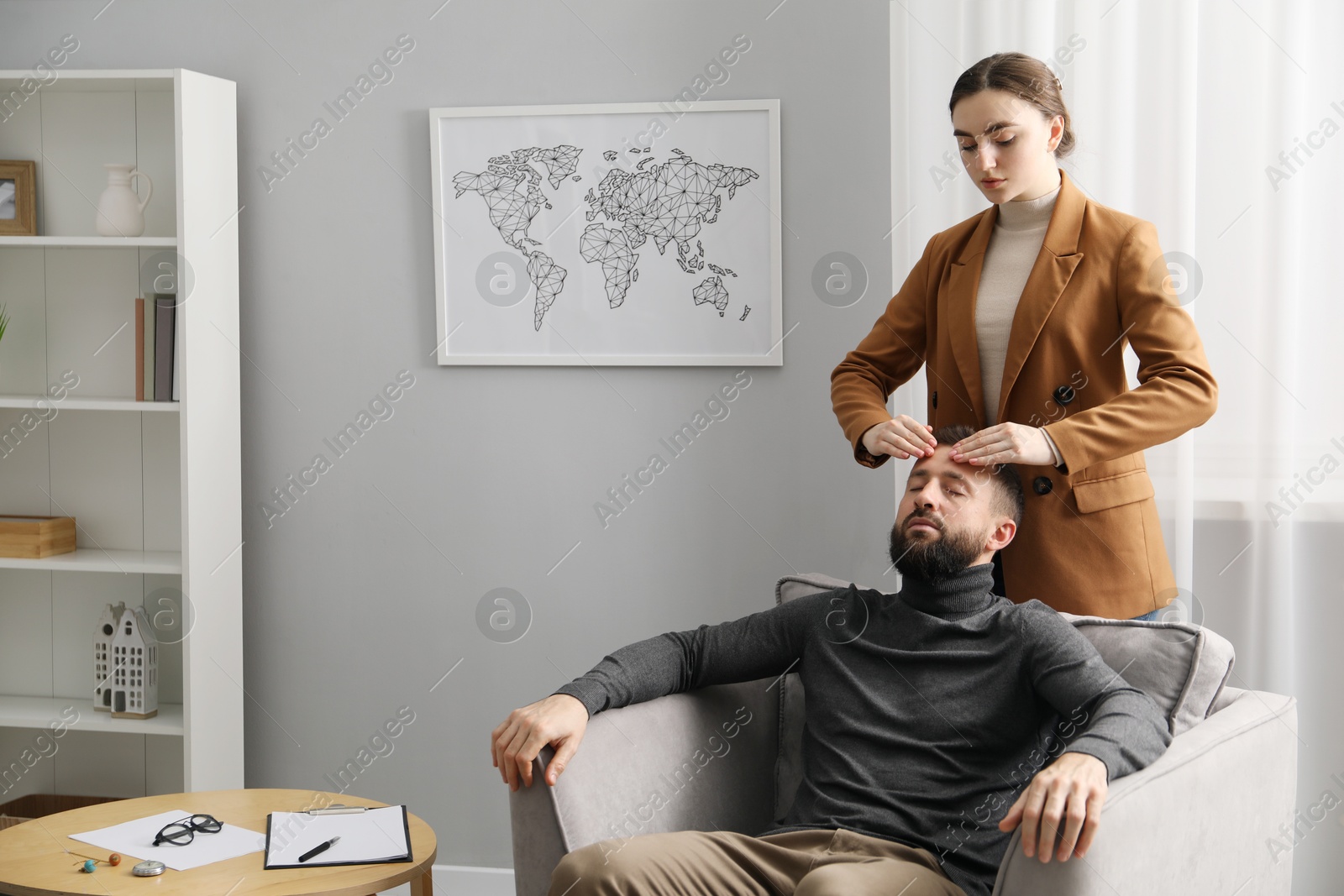 Photo of Psychologist working with patient during hypnosis session indoors