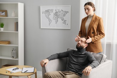 Photo of Psychologist working with patient during hypnosis session indoors