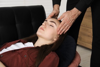 Photo of Psychologist working with patient during hypnosis session indoors, closeup