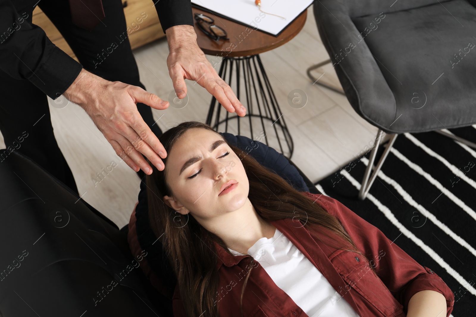 Photo of Psychologist working with patient during hypnosis session indoors, above view