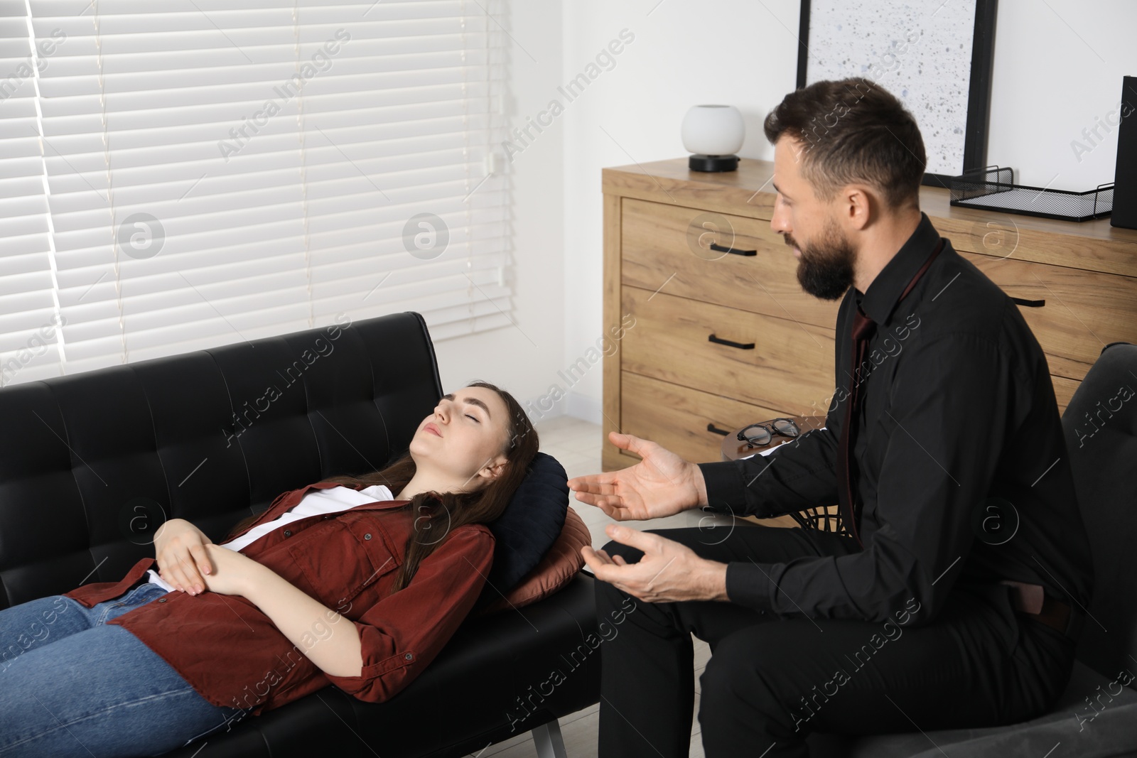 Photo of Psychologist working with patient during hypnosis session indoors