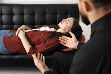 Photo of Psychologist working with patient during hypnosis session indoors, closeup