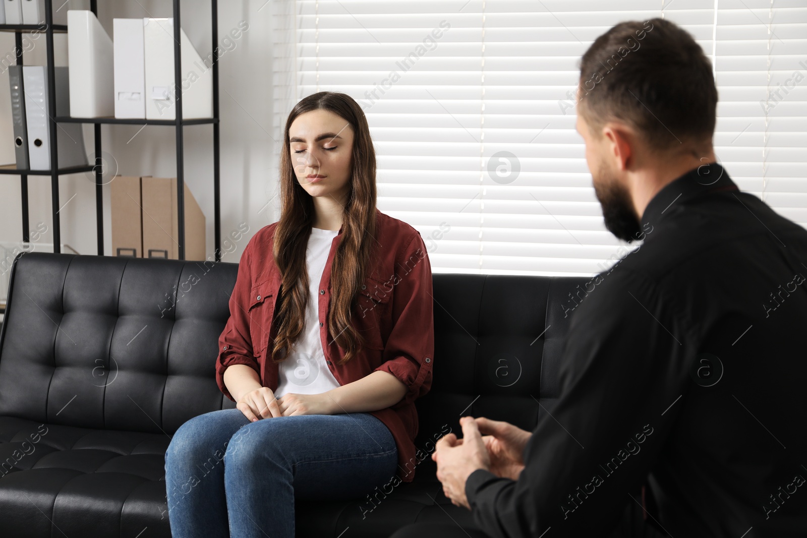 Photo of Psychologist working with patient during hypnosis session indoors