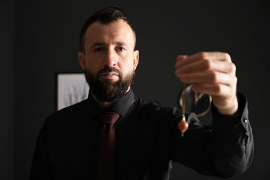 Photo of Hypnosis session. Man with pendulum in office