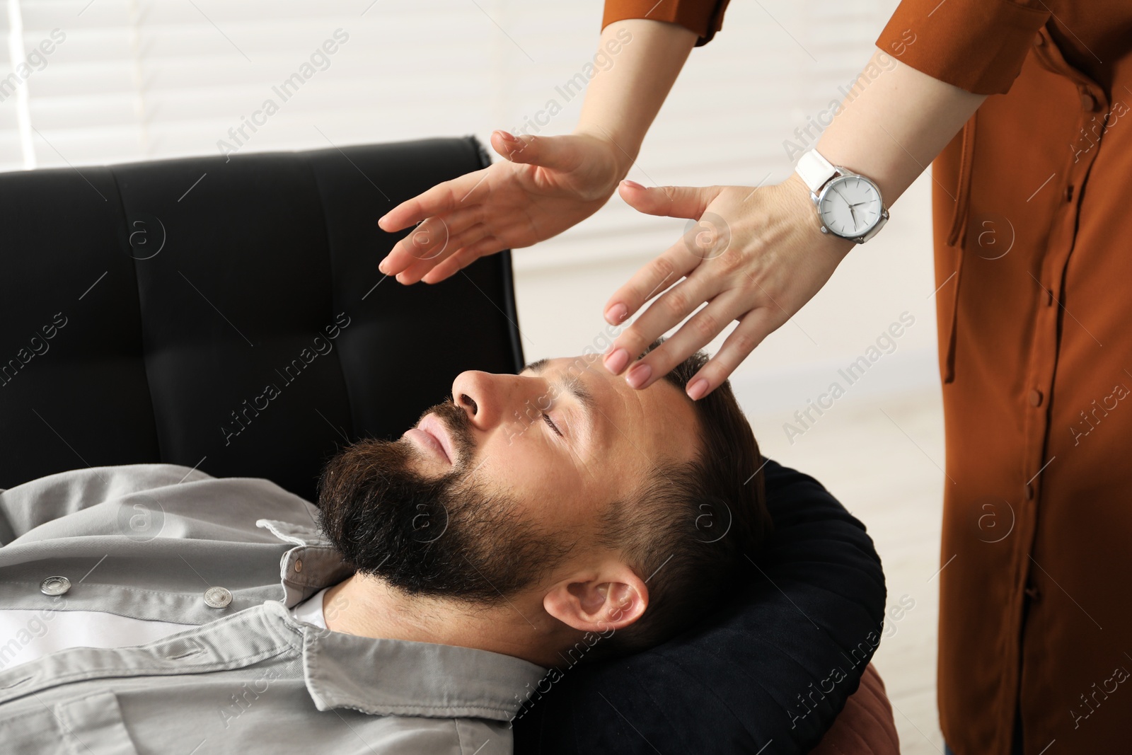 Photo of Psychologist working with patient during hypnosis session indoors, closeup