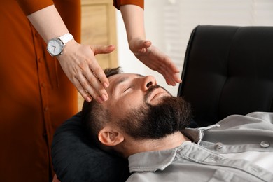 Photo of Psychologist working with patient during hypnosis session indoors, closeup