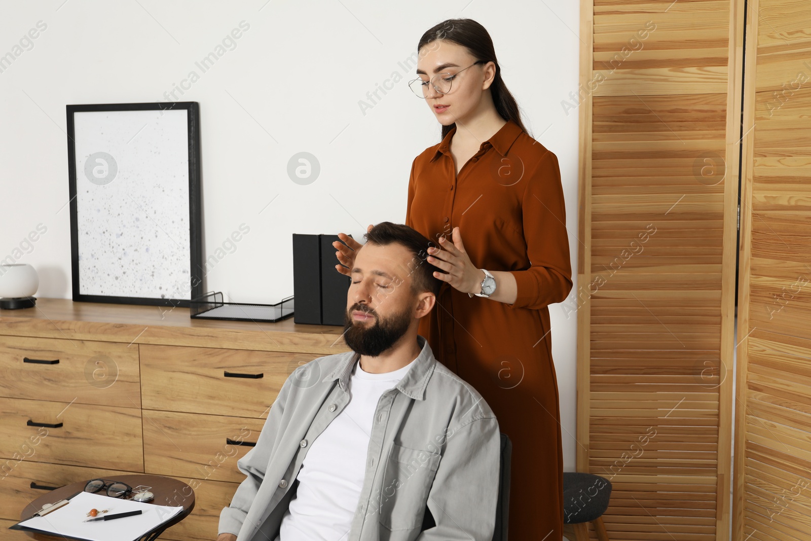 Photo of Psychologist working with patient during hypnosis session indoors