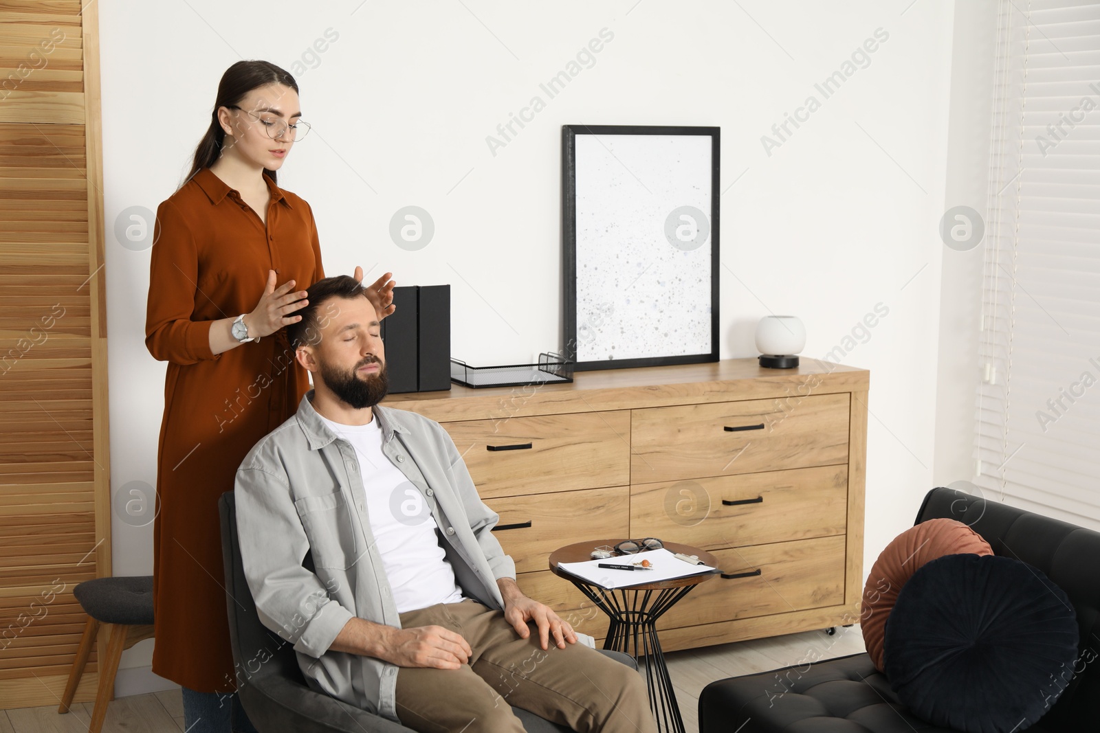 Photo of Psychologist working with patient during hypnosis session indoors