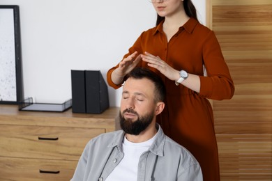 Photo of Psychologist working with patient during hypnosis session indoors, closeup