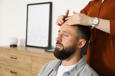 Photo of Psychologist working with patient during hypnosis session indoors, closeup. Space for text