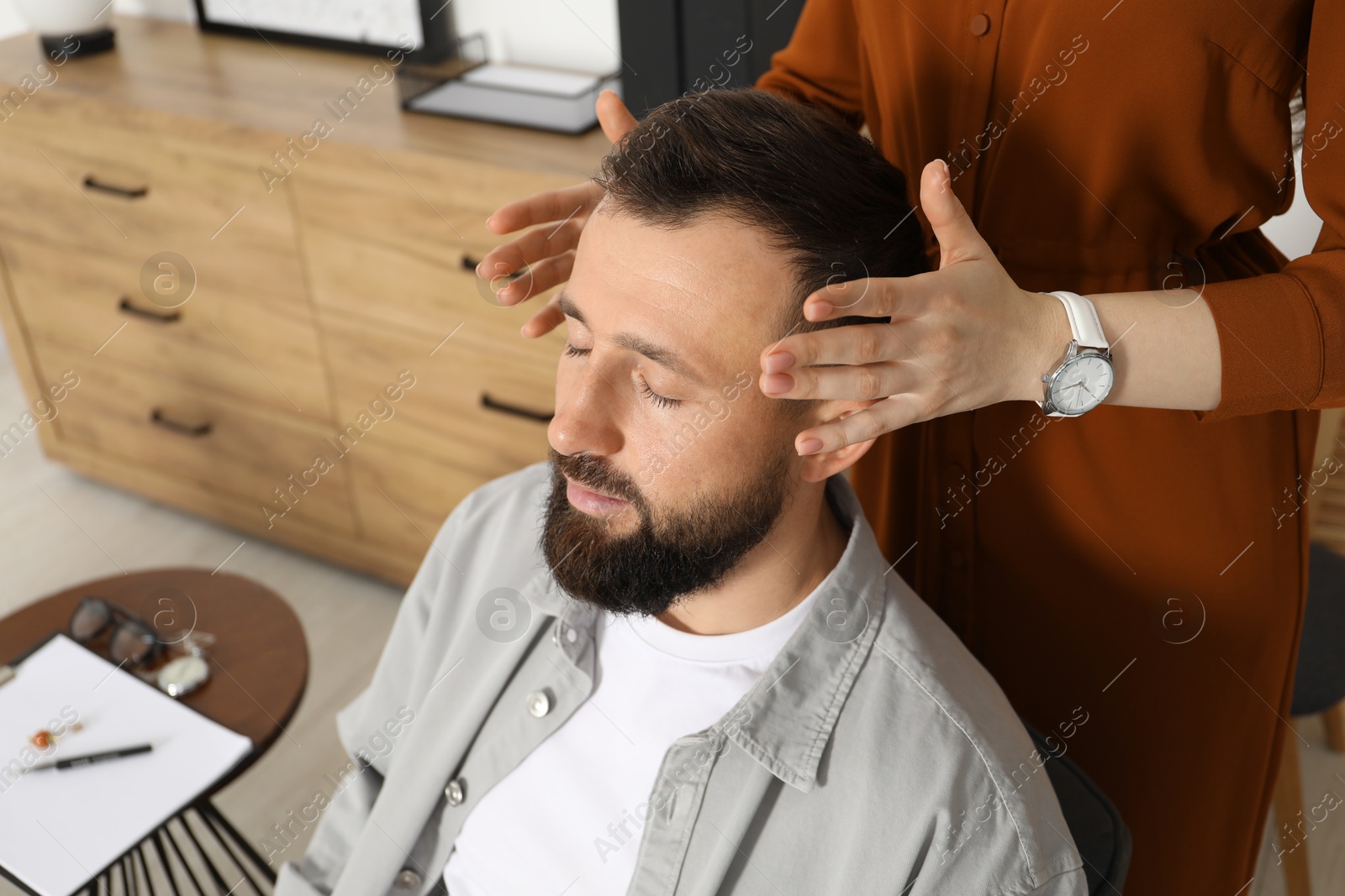 Photo of Psychologist working with patient during hypnosis session indoors, closeup