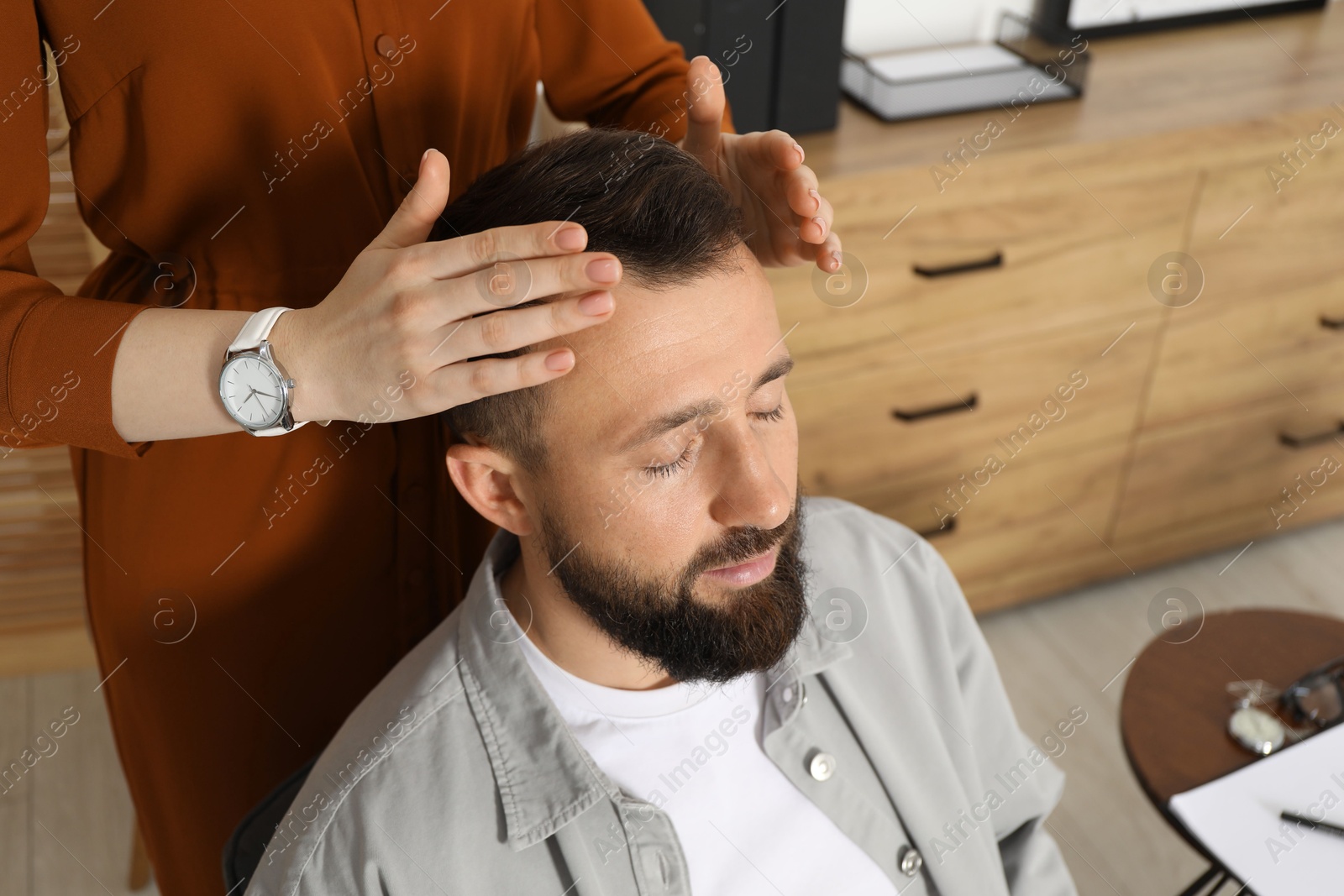 Photo of Psychologist working with patient during hypnosis session indoors, closeup