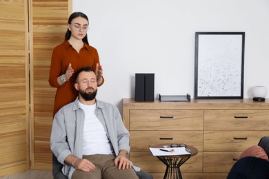 Photo of Psychologist working with patient during hypnosis session indoors