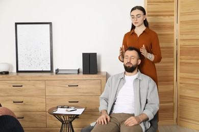 Photo of Psychologist working with patient during hypnosis session indoors