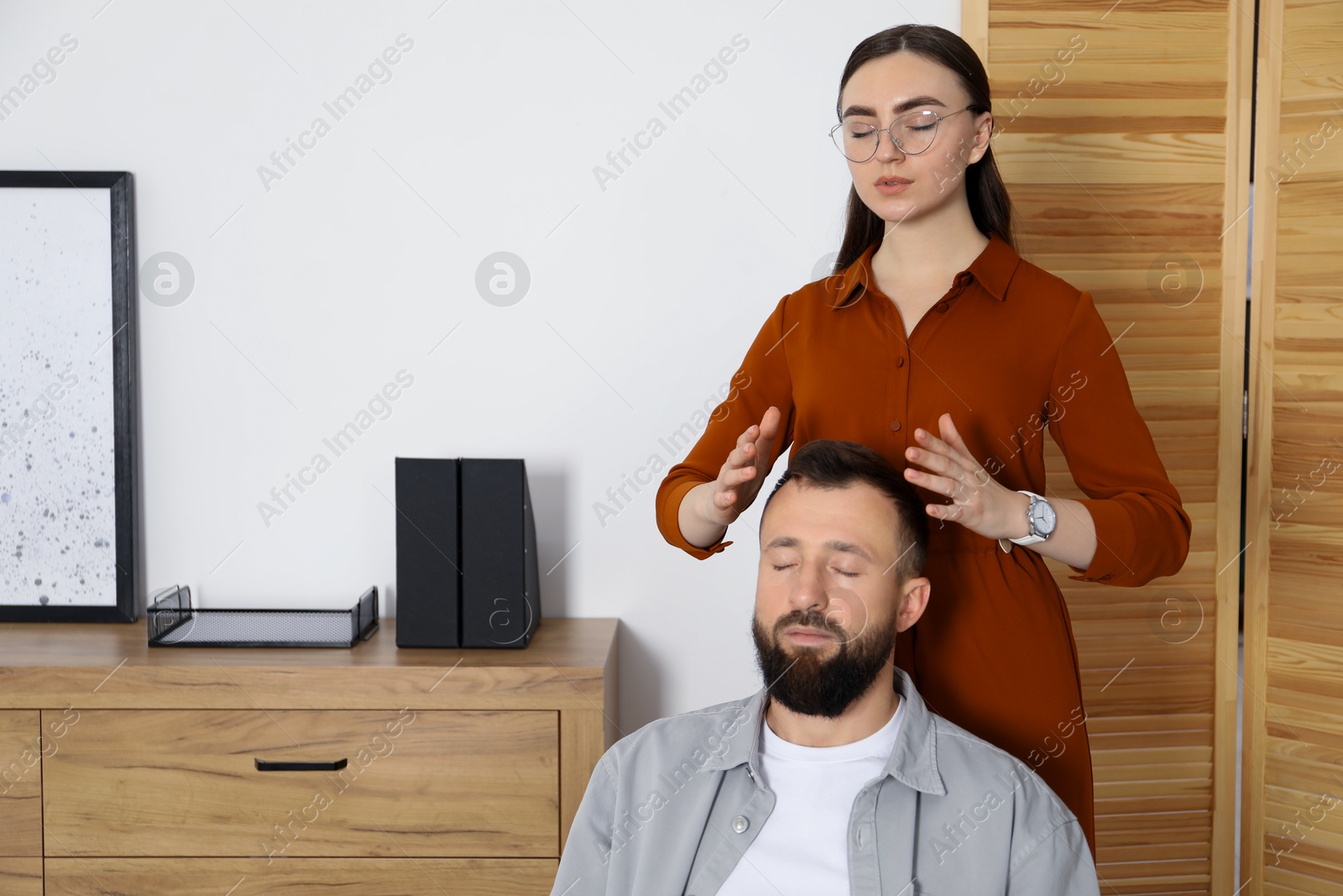 Photo of Psychologist working with patient during hypnosis session indoors