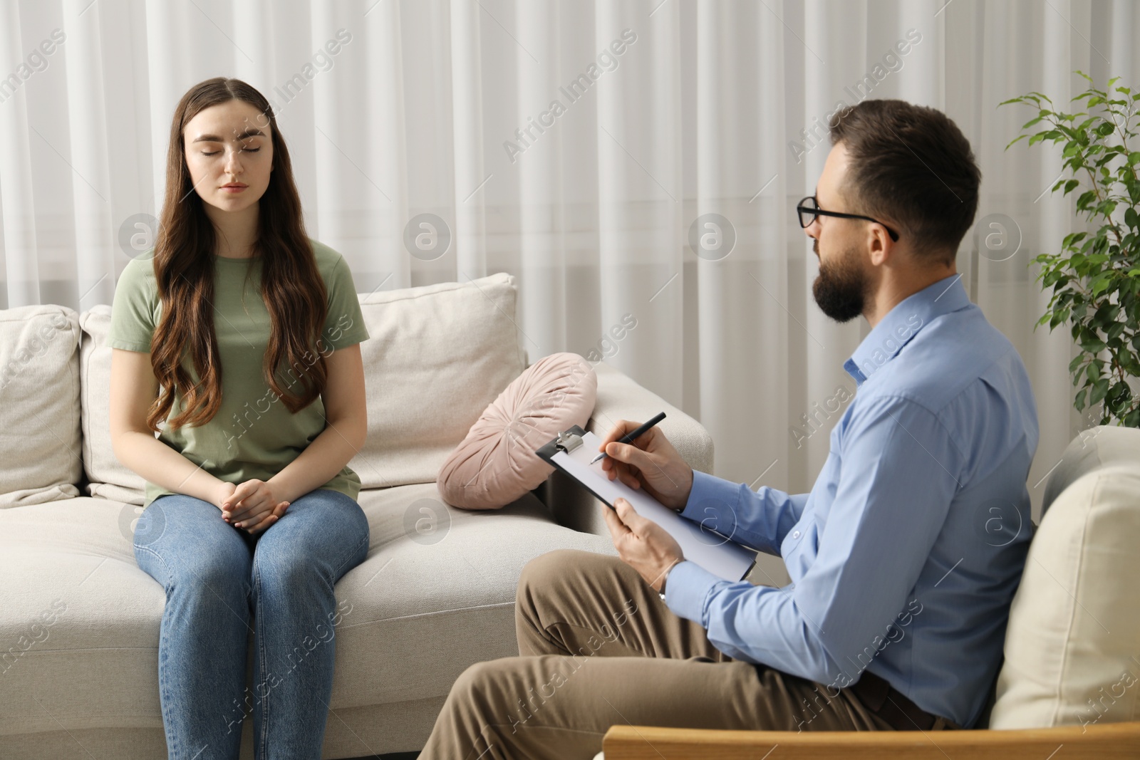 Photo of Psychologist working with patient during hypnosis session indoors