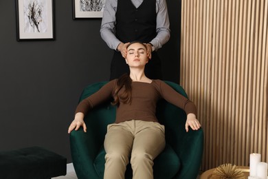 Photo of Psychologist working with patient during hypnosis session indoors, closeup