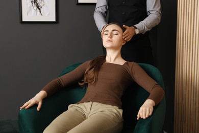 Photo of Psychologist working with patient during hypnosis session indoors, closeup