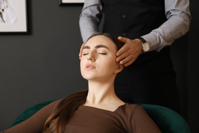 Photo of Psychologist working with patient during hypnosis session indoors, closeup