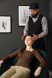 Photo of Psychologist working with patient during hypnosis session indoors