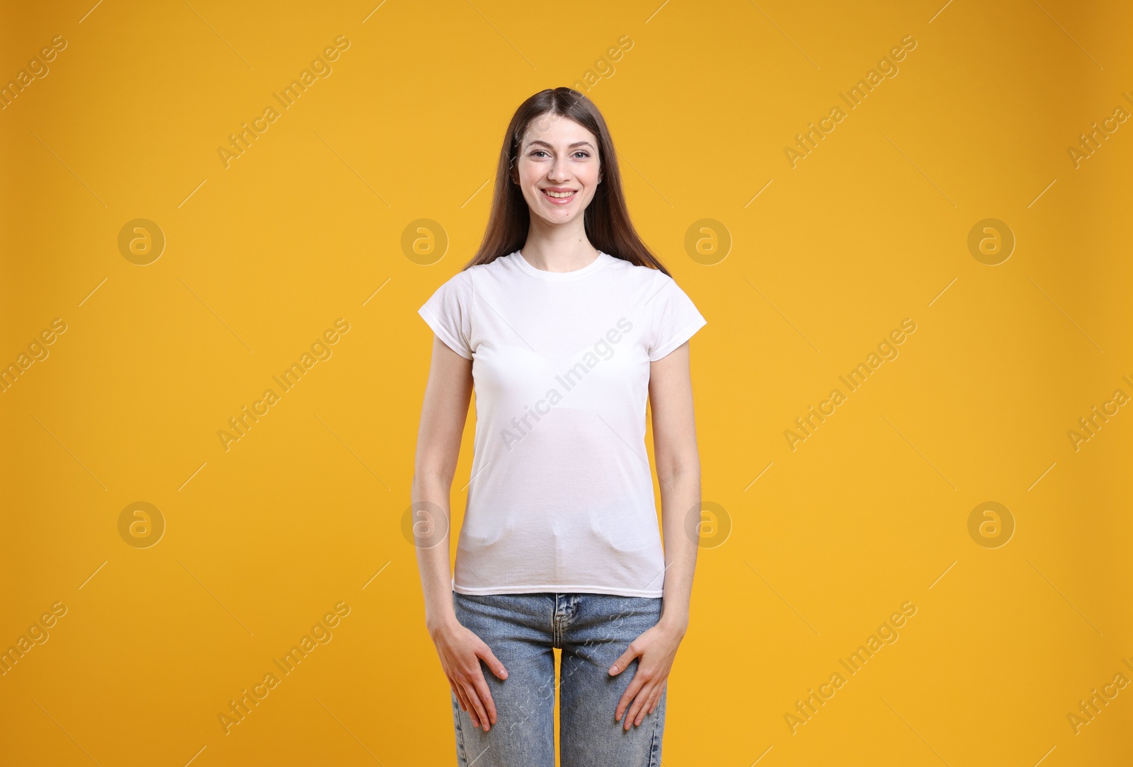 Photo of Woman wearing blank white t-shirt on orange background. Mockup for design