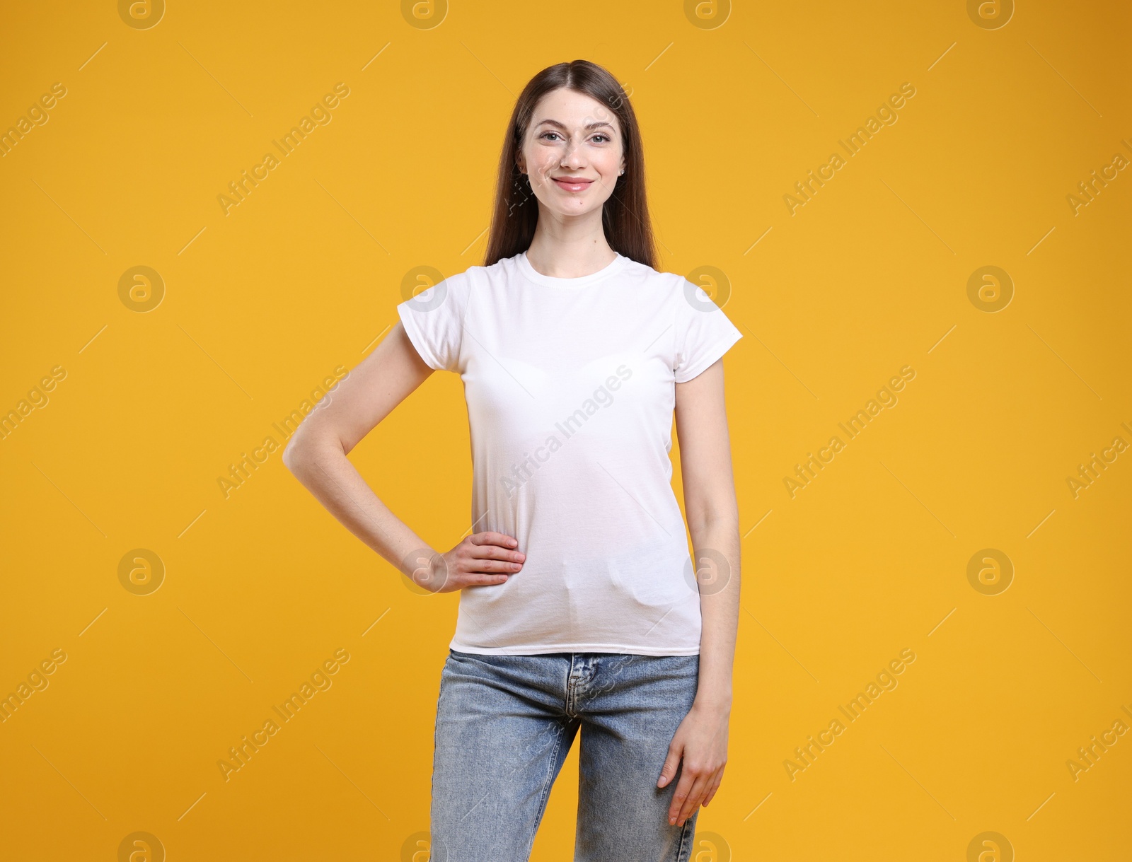 Photo of Woman wearing blank white t-shirt on orange background. Mockup for design