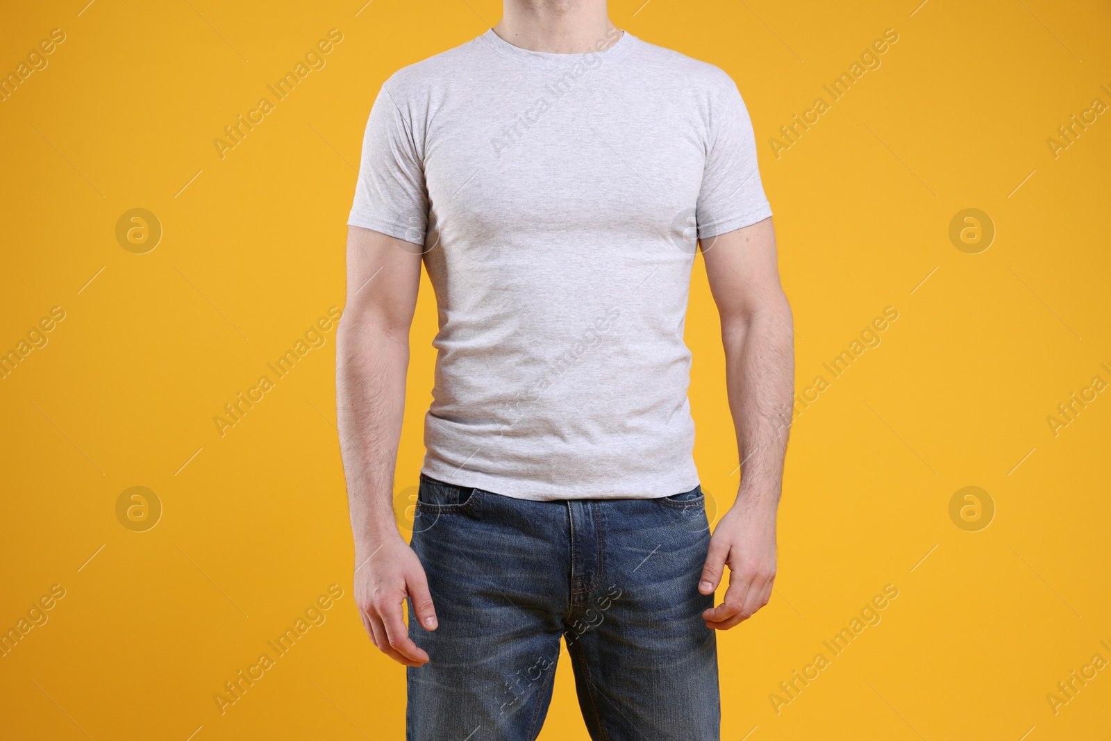 Photo of Man wearing blank white t-shirt on orange background, closeup. Mockup for design