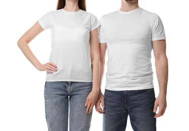 Photo of Woman and man wearing blank t-shirts on white background, closeup. Mockup for design