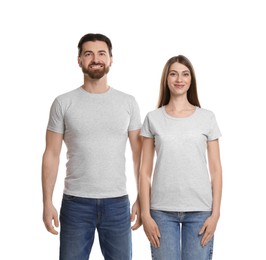 Photo of Woman and man wearing blank t-shirts on white background. Mockup for design