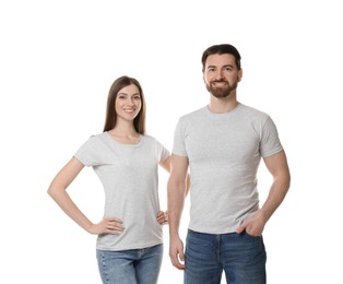 Photo of Woman and man wearing blank t-shirts on white background. Mockup for design