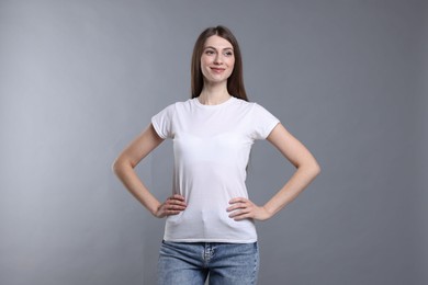 Photo of Woman wearing blank white t-shirt on light grey background. Mockup for design