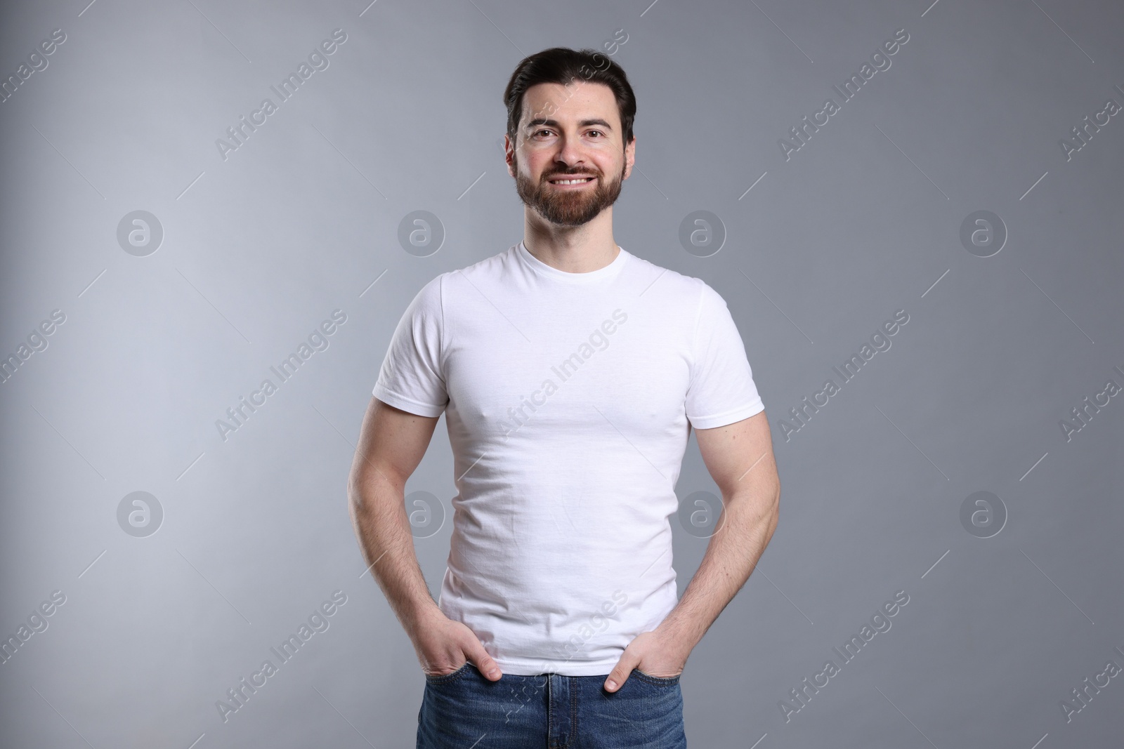 Photo of Man wearing blank white t-shirt on light grey background. Mockup for design