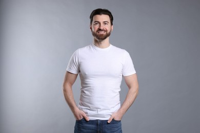 Photo of Man wearing blank white t-shirt on light grey background. Mockup for design