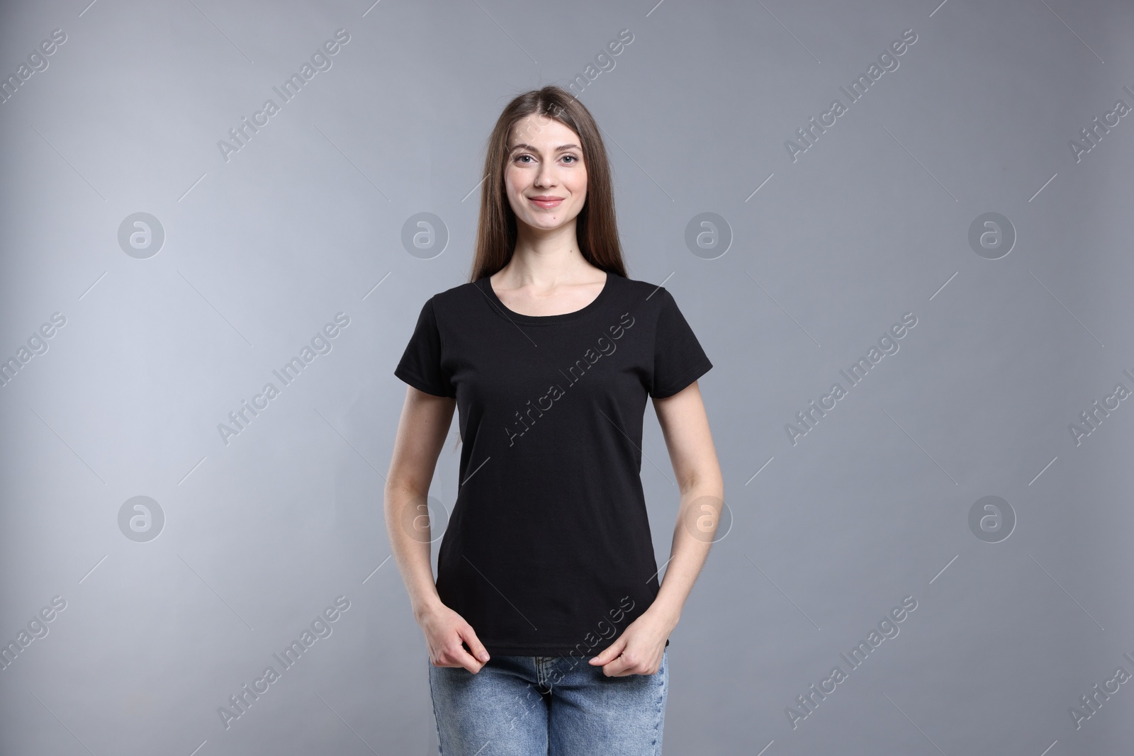 Photo of Woman wearing blank black t-shirt on light grey background. Mockup for design