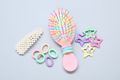 Photo of Different hair accessories and brush on grey background, flat lay