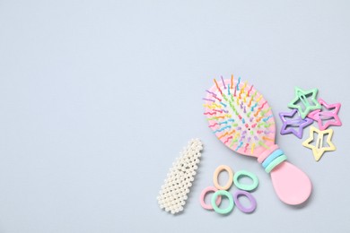 Photo of Different hair accessories and brush on grey background, flat lay. Space for text