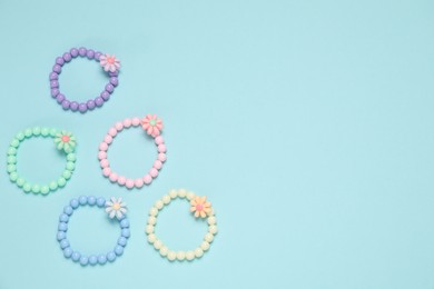 Photo of Different hair ties on light blue background, flat lay. Space for text