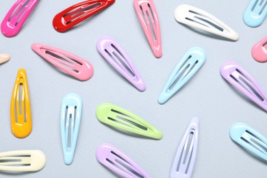 Photo of Different hair clips on grey background, flat lay