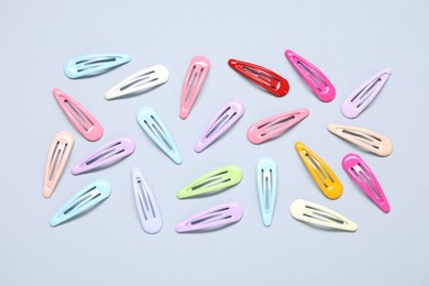 Photo of Different hair clips on grey background, flat lay