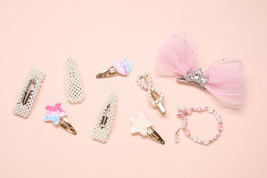 Photo of Different hair clips and bracelet on beige background, flat lay